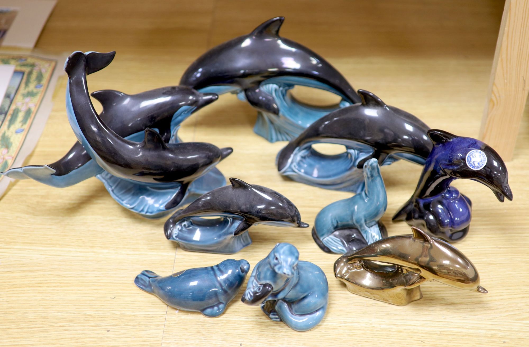 Six Poole pottery dolphins together with two similar seals and an otter